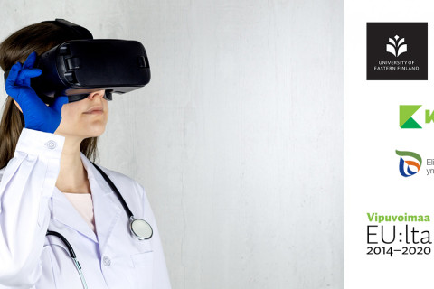 Labratakkinen henkilö, jolla vr-lasit kasvoilla, suojahansikas kädessä, stetoskooppi kaulalla.