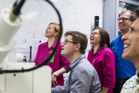 Five people working in a laboratory.
