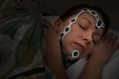 Nukkuvan naisen päähän kiinnitetyt sensorit.