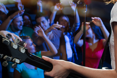 Kitaristi esiintyy yleisön edessä.