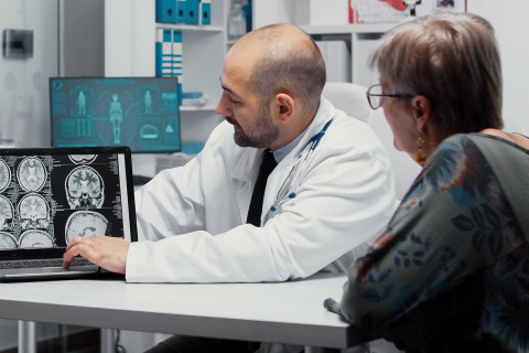Lääkäri selittää aivokuvien tuloksia potilaalle.