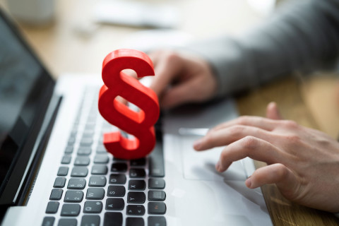 Punainen lakipykälä-merkki kannettavan tietokoneen näppäimistön päällä