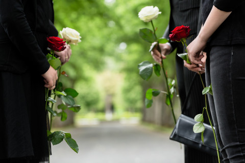 Surevat omaiset ruusujen kanssa hautajaisissa.