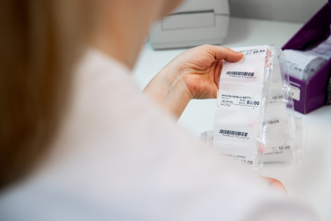 Apteekin työntekijä käsittelee annosjakelupusseja.