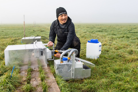 Zheng Yu taking measurements on peatland field.