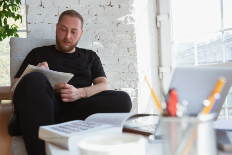 Mies opiskelee kotona.