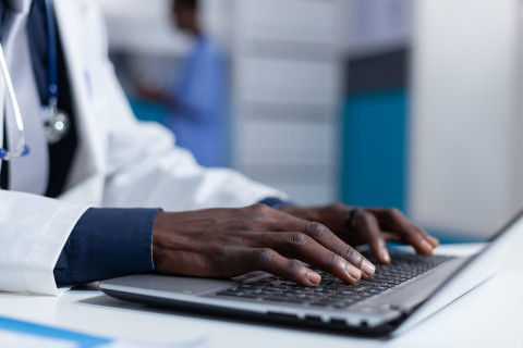 Doctor&#039;s hands on a laptop keyboard.