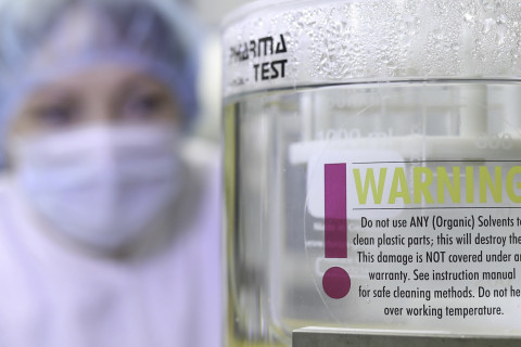 Henkilö tarkastelee lääkkeiden tesitilaitteistoa.