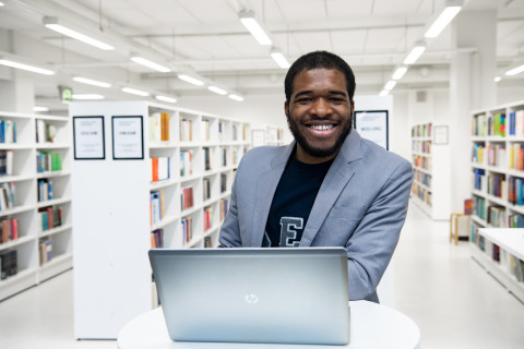 Promo picture of a Master&#039;s student in a library