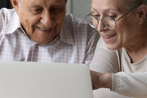 Vanha mies ja nainen tietokoneen ääressä.