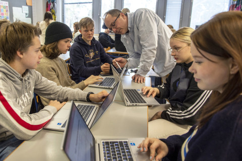 Oppilaat ja opettaja.