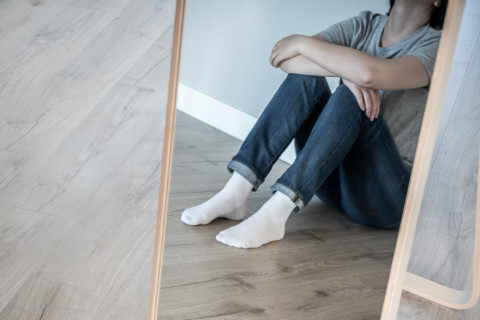 Henkilö istuu lattialla.