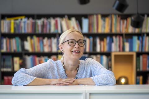 JOK_kysy_lupa_nainen kirjastossa nojaa hyllyyn