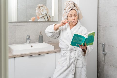 JOK nainen opiskelee samalla kun pesee hampaita