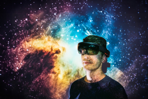 Tekniikan opiskelija ar-lasit päässä, taustalla kuva avaruudesta