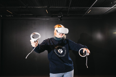 Nainen pelaamassa virtuaalitodellisuudessa.