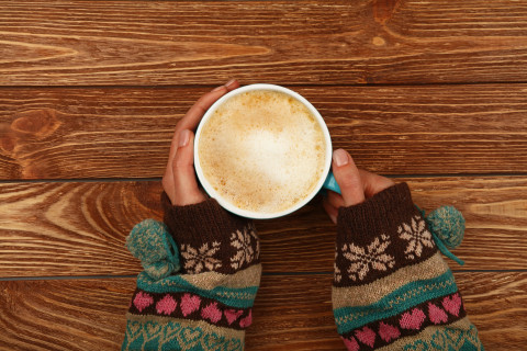 Hands holding a coffee cup.