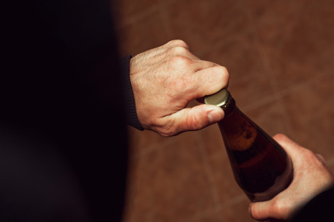 Hands and a beer bottle.
