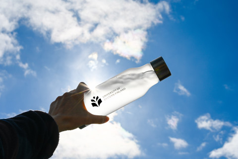 UEF-juomapullo vasten kesäistä taivasta.