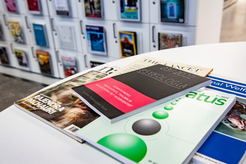 Tieteellisiä lehtiä pöydällä ja lehtikaapissa.