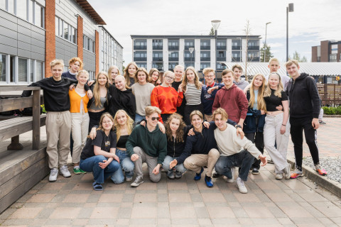 Ryhmäkuva lukiolaisista seisomassa pihalla