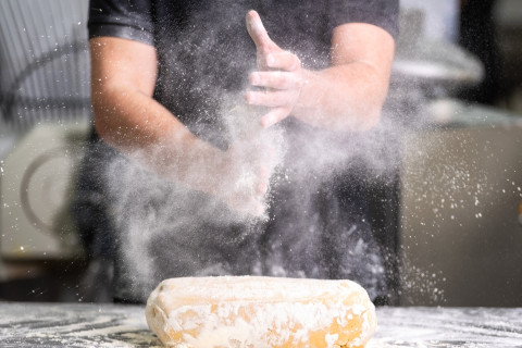 Pastry chef clapping his hands with flour while making dough. Photo Mostphotos.