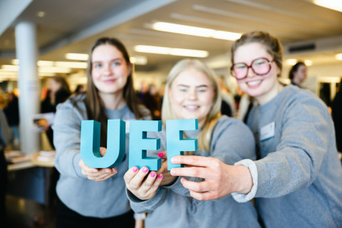 Persons are holding UEF letters in their hands.