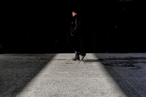 Ihminen kävelee kadulla seinän vierustaa.