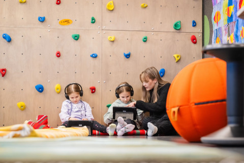 Opettaja tekemässä koululaisten kanssa tehtäviä.