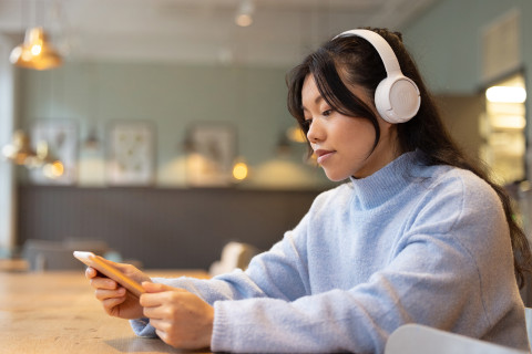 A person using Celia services with their smartphone and headphones.