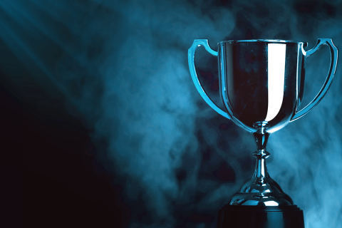 Tummalla taustalla siniset valot kohdistuvat pokaaliin