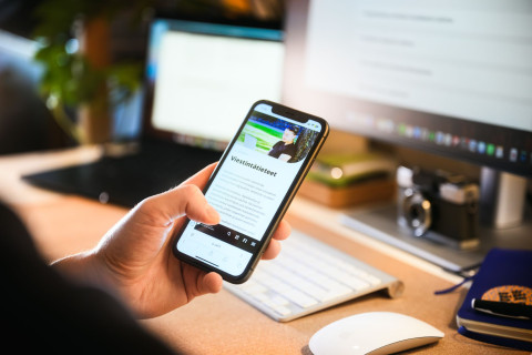 Henkilö selaamassa verkkosivuja puhelimella.