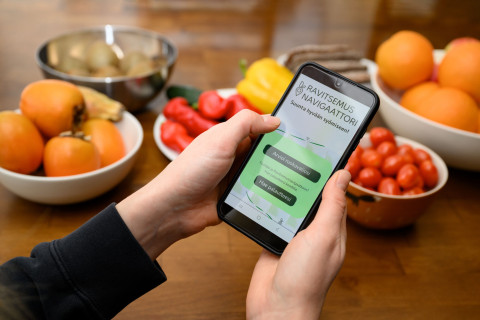 Foodnutri-hankkeen ravitsemusnavigaattori-verkkopalvelu puhelimen näytöllä ja ruokatarvikkeita.