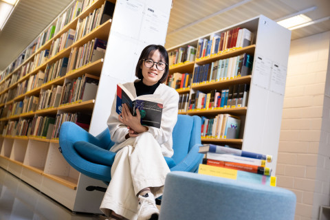 Student sitting on a bench and reading a book