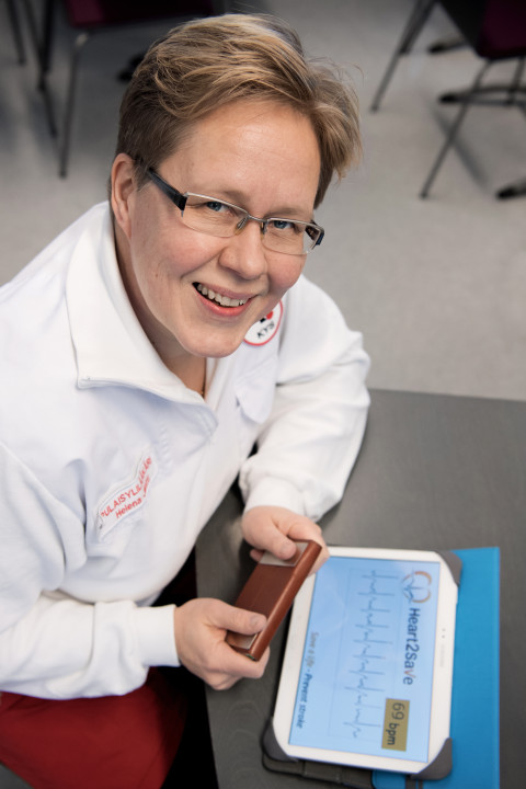 Photo of Helena Jäntti in front of a tablet with the Heart2Save app open.