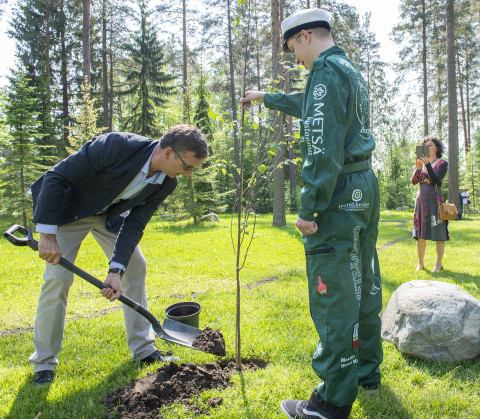 Kunniatohtori Alain Tremeau istuttaa puuta metsäylioppilaiden avustuksella.