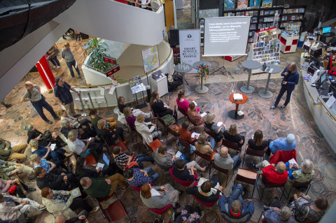 Tutkija luenno yleisölle kauppakeskuksessa.