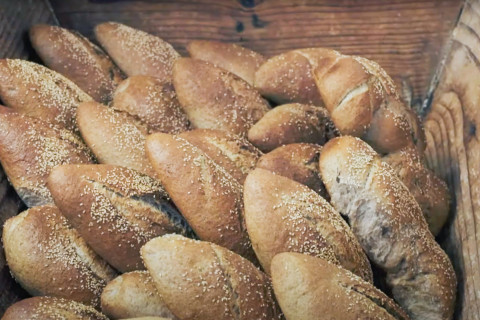 Puulaatikossa paljon tuoreita leipiä.