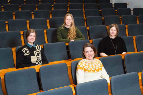 Henkilöitä istumassa salissa.