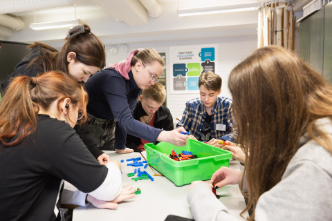 Yläkoulun oppilaat tekevät oman maan lippua legoista.