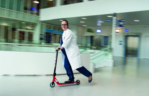 Milla-Maria Tauriainen kulkee potkulaudalla sairaalan aulassa