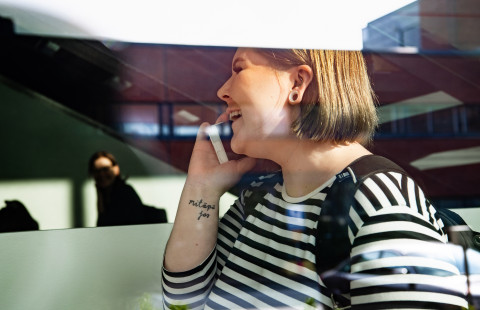 opiskelija puhelimessa lasin takana