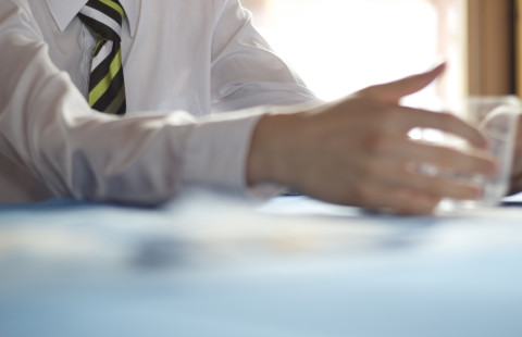 Neuvotteluun osallistuvan käsi pöydällä