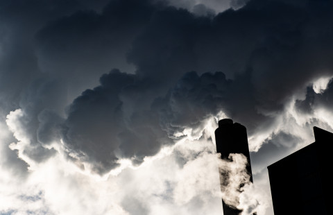 Photo of a factory pipe emitting smoke in the air.