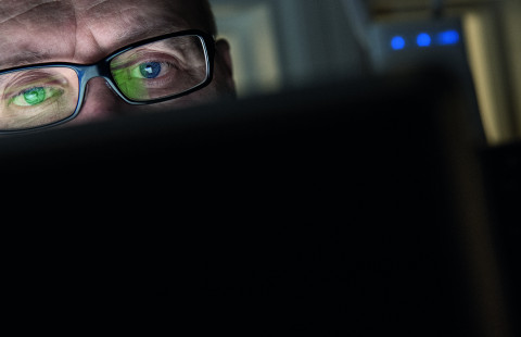 Henkilö lukee uutisia tietokoneelta