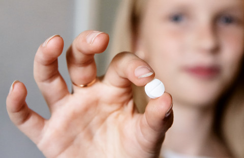 Lääkepilleri lapsen kädessä