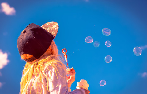 Lapsi puhaltaa saippuakuplia