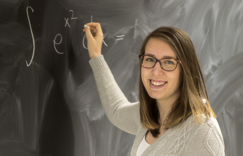 Opiskelija taulun edessä.