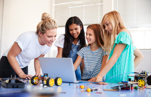 Teacher and pupils on a computer.
