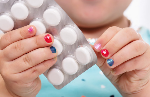 Child holding a blister pack.